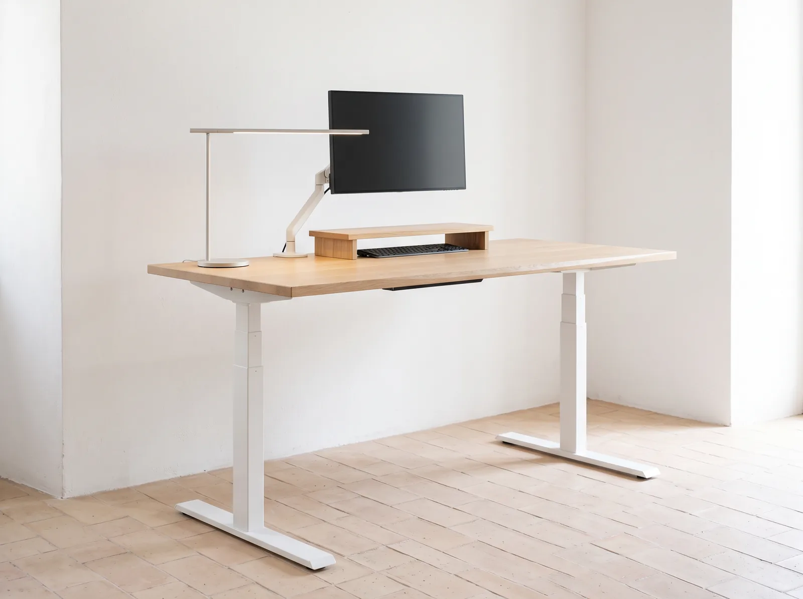 Ein Apex Pro in Weißeiche auf kalkweißem Rahmen in einem weiß getünchten Studio, ein Display auf einem Holzregal erhöht, die Tastatur darunter geschoben.